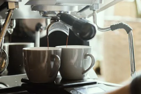 Close-up of espresso pouring from coffee machine. Professional coffee brewing Stock Photos