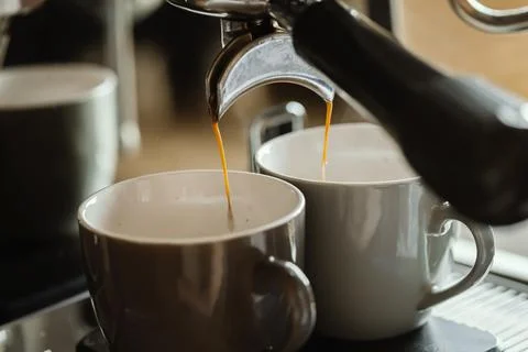 Close-up of espresso pouring from coffee machine. Professional coffee brewing Stock Photos