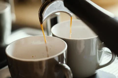 Close-up of espresso pouring from coffee machine. Professional coffee brewing Stock Photos