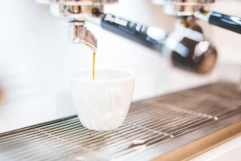 Close-up of espresso pouring from coffee machine. Professional coffee brewing Stock Photos