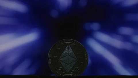 Close-up: Ethereum physical coin on an abstract background. Golden ETH logo with Stock Footage 332620036