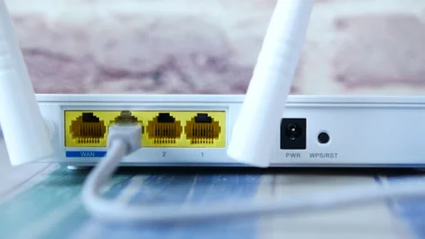 Close up of an ethernet cable being inserted into a white wireless internet.. Stock Footage 333032471