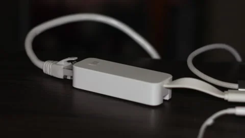 Close up of an Ethernet to USB-C Network Adapter on a Dark Wooden Table Stock Footage 337425082