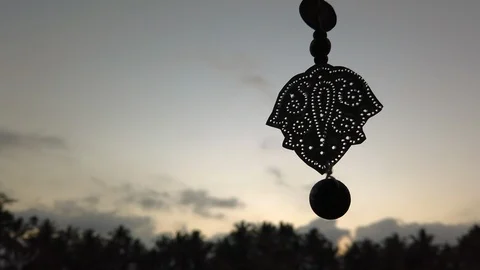 Close up of an ethnic pendant during sunset, silhouette, slomo, 4K Video stock 120952671