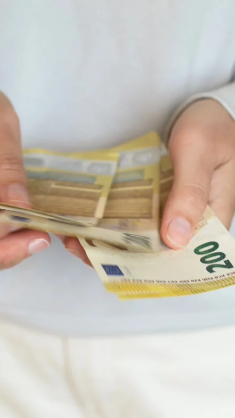 Close-up of euro banknotes in hands symbolizing tax payments, financial Stock Footage 332904379