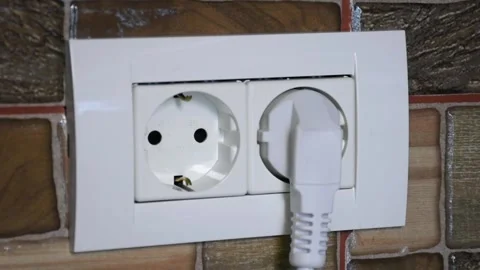 Close-up of the European wall power socket being plugged and unplugged by 動画素材 140987562