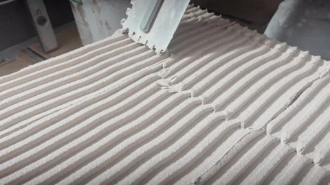 Close-up of evenly combed tile adhesive with parallel ridges, showing precise Vídeos de archivo 345078813