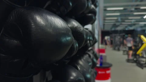 Close examination of leather boxing gloves with gym background showcasing Stock Footage 327417432