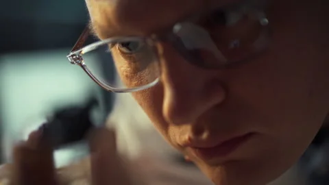 Close examination of a small object by a focused individual in a creative wo Stock Footage 323730456