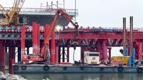 Close up of an excavator &amp; construction vessels operate on the Qiantang River Stock Footage 335886281
