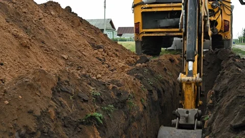 Close up of an excavator digging a deep trench Stock Footage 157803486