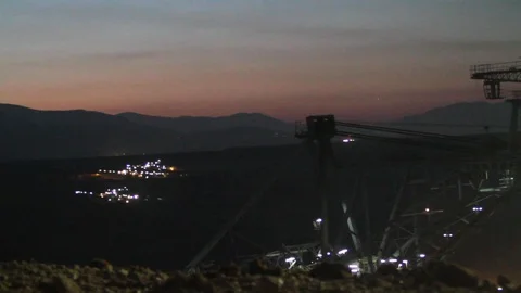 Close up of an excavator operating at night with lights in the backdrop Stock Footage 121410200