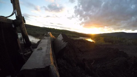 Close up of excavator picking up piles of clay outside in sunset Stock Footage 138896074