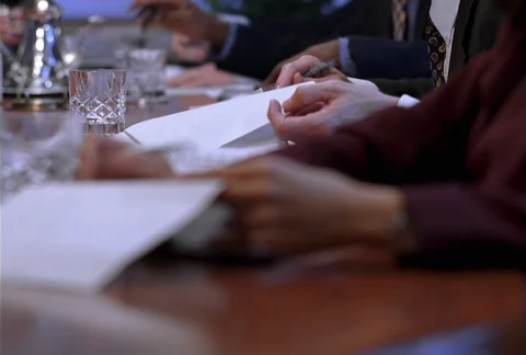 A close-up of executives' busy hands are seen flipping through the pages of Stock Footage 86773292