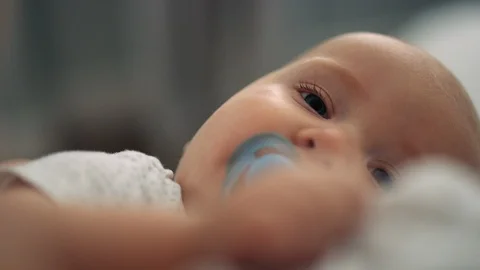 Close on exhausted baby's face as he fights sleepy feeling slow motion Stock Footage 122601957