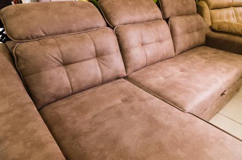 Close-up of an expensive soft textile sofa of beige color with brown shades Stock Photos