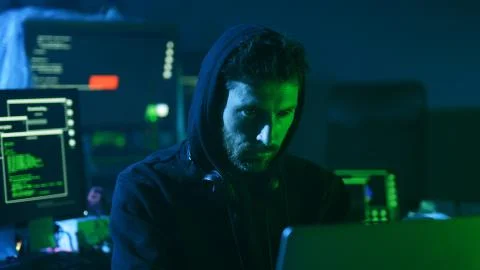 Close-up of experienced computer hacker at work. Portrait of concentrated young 스톡 사진
