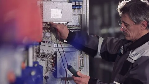 Close-up of experienced man working with electric meter. Stockbeeldmateriaal 77107203