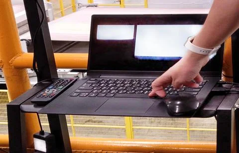 Close up of expert engineer using laptop to control production circuit board 库存照片
