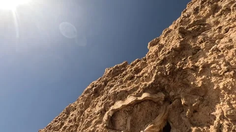 A Close-Up Exploration of Textured Rocky Terrain Under Clear Blue Skies, Stock Footage 330185141