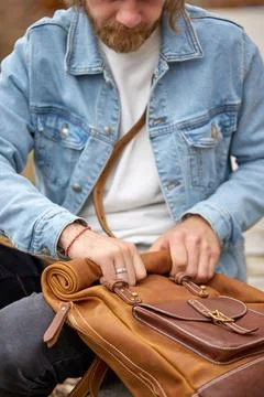 Close up of explorer man holding brown handmade backpack in retro style Stock Photos