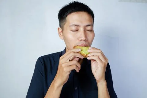 Close-up expression of asian man's face eating cake Stock Photos
