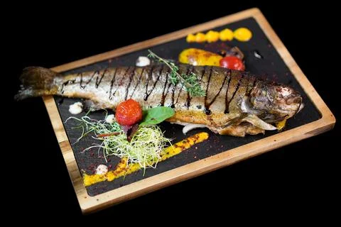 Close up of an exquisite serving of a special dish from the chef on a black b Stock Photos
