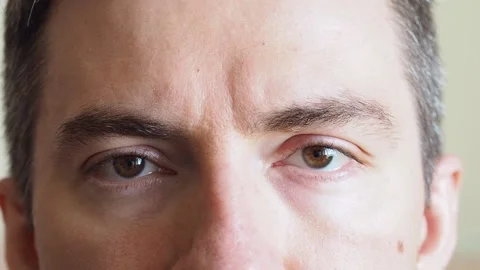 Close-up of the eye of a blinking brown-eyed man Stock Footage 194410031