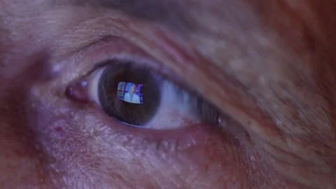 Close-up eye of an elderly man watching the news 動画素材 135318023