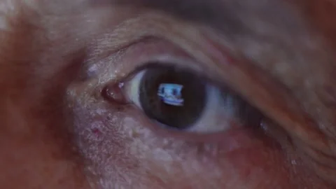 Close-up eye of an elderly man watching the news Stock Footage 137229120