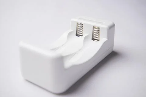 Close-up, eye-level shot of an empty white universal battery charger with t.. Stock Photos