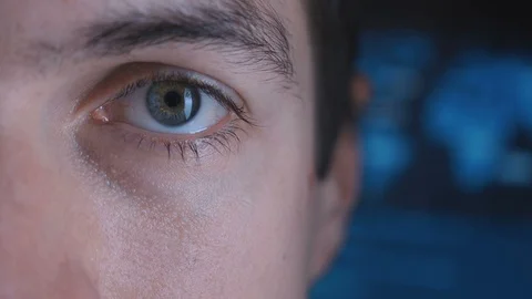 Close-up Eye in macro of a Male Programmer Geek in a data center filled with Video stock 100853154