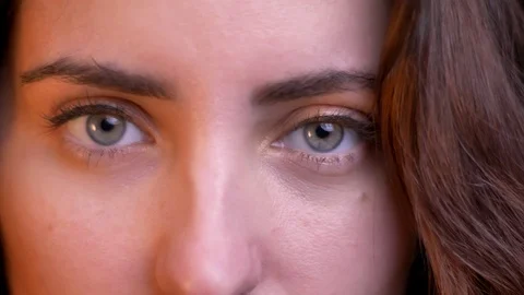 Close-up eye-portrait in profile of young caucasian girl watching smilingly and Stock Footage 103590202