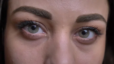 Close-up eye-portrait of young long-haired brunette caucasian girl watching Video stock 102575426