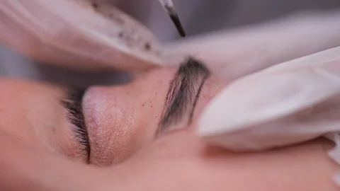 Close-up. Eyebrow, on which a specialist inject a needle and apply a pigment 库存影片 106893062
