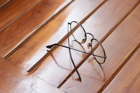 A close up of eyeglasses with black frames isolated natural patterned woode.. Stock Photos