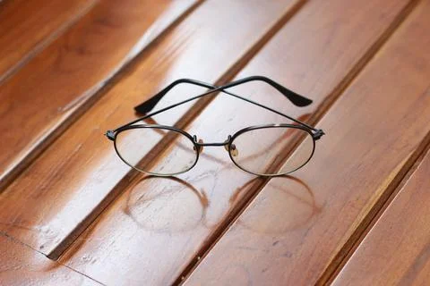 A close up of eyeglasses with black frames isolated natural patterned woode.. Stock Photos