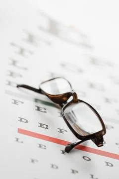 Close up of eyeglasses on eye chart Stock Photos