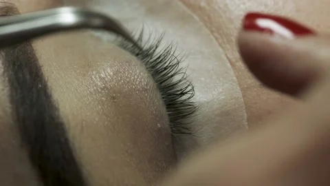  Close-up of the eyelash extension process. Top view of gluing artificial eyelas Stock Footage 106957006