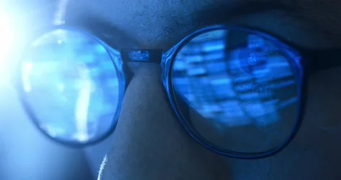 Close-up eyes in glasses of man programmer working at computer at night, the Stock-Footage 233432363