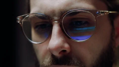 Close-up eyes in glasses of man programmer working at computer at night, light Stock Footage 263546548