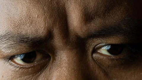 Close up of eyes looking forward, with a slightly wrinkled facial expression Stock Photos