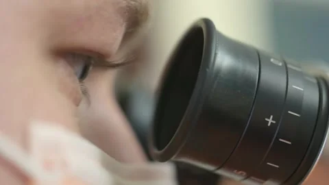 Close-up eyes looking through a microscope. Close-up of a man looking through a Stock-Footage 253334839