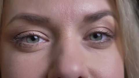Close-up eyes portrait of middle-aged blonde businesswoman watches contentedly Stock-Footage 107780459