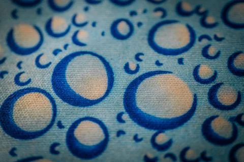 Close-up of fabric with blue circular patterns resembling bubbles on a ligh.. 库存照片