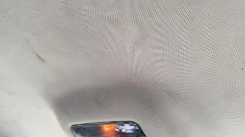Close-up of the fabric headliner and dome light in a car ceiling, vehicle Stock Footage 337113797