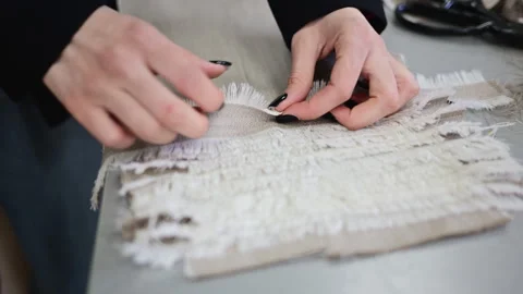 Close up of fabric layers being aligned and inspected, showing raw edges and Stock Footage 335870241
