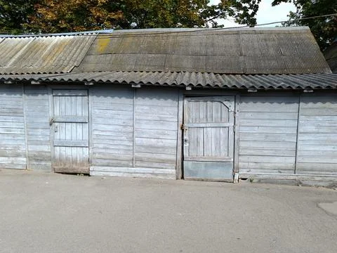 Close up facade of an old rustic wooden barn with a slate roof Stock Photos
