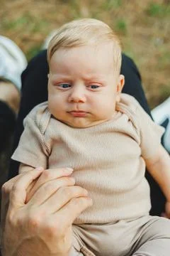 A close-up of the face of a 2-month-old boy in his mother's arms. The baby .. Foto stock