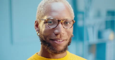 Close up face of bearded black man wearing glasses and earring looking at camera Stock Footage 163145454